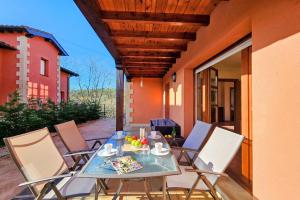 a table and chairs sitting on a porch with a table and chairs at Playa de La Franca, jardín y WiFi - Casa Freya in La Franca
