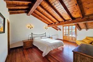 a bedroom with a large bed and wooden ceilings at Playa de La Franca, jardín y WiFi - Casa Freya in La Franca
