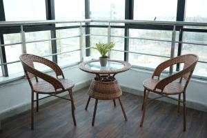 two chairs and a table with a plant on a balcony at Hotel Elite Executive Lodging in Bārāmati