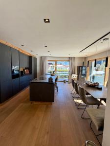 a kitchen with a table and chairs and a dining room at MALIA - Alpine Hideaway in Pertisau
