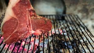 a piece of meat is cooking on a grill at Albergo Lago Verde in Pennabilli