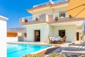 a villa with a swimming pool and a house at Kalisto Beach Villa in Kato Yialia