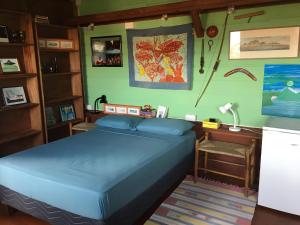 a bedroom with a blue bed and a desk at Italian Guesthouse in Gros Islet
