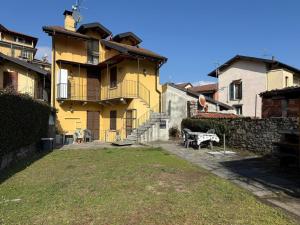 a yellow building with a bench in front of it at Casa Zia Pia in Baveno
