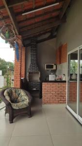 a living room with a chair and a stove at Complete Chácara Pool, WiFi 5min Thermas in São Pedro