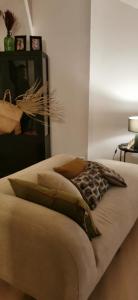 a bed with brown pillows on it in a room at Chez Ariel et Myrtille in Bruyères