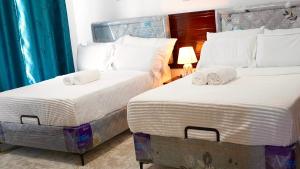 two beds sitting next to each other in a bedroom at The Initial Residence in Mombasa +30 photos