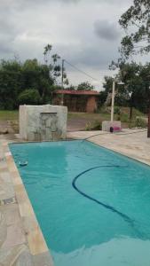 a swimming pool with blue water in a yard at Complete Chácara Pool, WiFi 5min Thermas in São Pedro