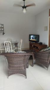 a living room with a table and chairs and a television at Complete Chácara Pool, WiFi 5min Thermas in São Pedro
