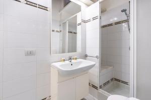 a white bathroom with a sink and a mirror at Corso Double in Florence