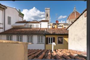 a view of the roofs of buildings with a clock tower at Corso Double in Florence