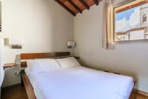 a bedroom with a white bed and a window at Corso Double in Florence