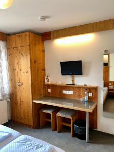 a room with a desk with a tv on a wall at Hotel Feuerbacher Hof in Stuttgart