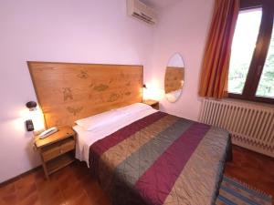 a bedroom with a bed and a wooden headboard at Albergo Lago Verde in Pennabilli +36 photos