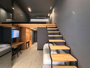 a room with a staircase with a couch and a tv at Gest Hotel in Radhimë
