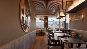 a restaurant with tables and chairs and a large mirror at B&B HOTEL Covilhã in Covilhã