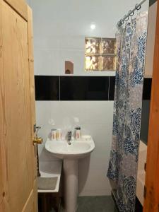 a bathroom with a sink and a shower curtain at Casa Silvina Tarrafal in Tarrafal +50 photos