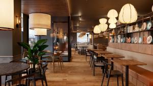a restaurant with tables and chairs and lights at B&B HOTEL Covilhã in Covilhã