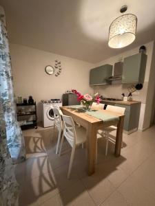 a kitchen with a wooden table and white chairs at CASA ELISA in Cavo