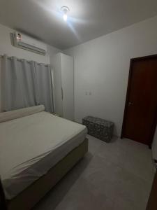 a small bedroom with a bed and a door at Casa de praia PB in Pitimbu +6 photos