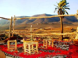 a table and chairs with a view of the desert at Tarmguist in Tighmert