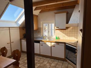 a kitchen with white cabinets and a skylight at Apartment in Düdingen in Düdingen