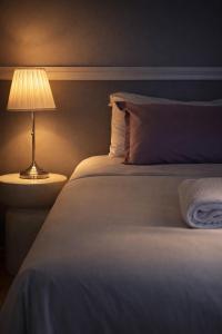 a bedroom with a bed with a lamp on it at Hótel Lækur in Hella