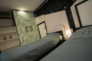 1 dormitorio con 2 camas y pared en Ghoyhuys en Leiderdorp
