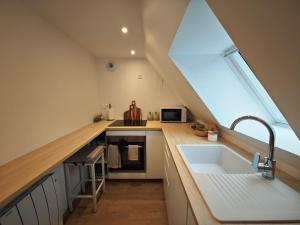 an attic kitchen with a sink and a window at Slow Suite & Spa Erstein in Erstein