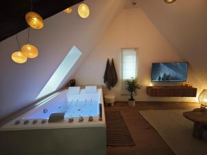 a living room with a tub in the attic at Slow Suite & Spa Erstein in Erstein