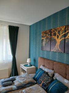 a bedroom with a bed and a tree painting on the wall at Natura Lux & Parking Free - Green Hill, blizu Akva parka in Soko Banja