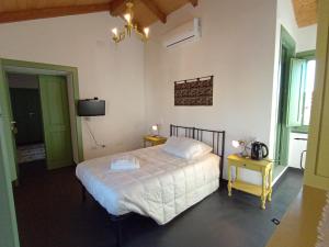 a bedroom with a white bed and a chandelier at La Casa Vecchia in Nuraminis