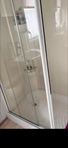 a shower with a glass door in a bathroom at Trailer by the sea in Millom +6 photos
