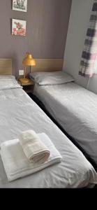 two beds in a room with white towels on them at Trailer by the sea in Millom