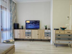 a living room with a television on a wooden cabinet at Ines - Golf und Meer Bulgarien in Balchik