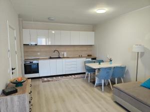 a kitchen with white cabinets and a table and chairs at Ines - Golf und Meer Bulgarien in Balchik