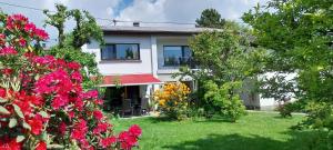 a white house with flowers in the yard at Ferienwohnung Bliestalglück mit Balkon & Terrasse in Oberthal