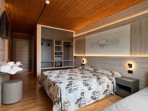 a bedroom with a bed and a wooden ceiling at Hotel Vezzena in Malga Postesina +24 photos