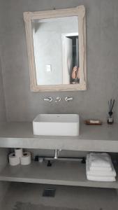 a bathroom sink with a mirror and a person taking a picture at Como en casa in Concordia +15 photos