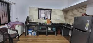 a kitchen with a black counter and a refrigerator at Daji Dhabolkar house in Mandrem +3 photos