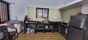 a kitchen with a black counter and a refrigerator at Daji Dhabolkar house in Mandrem