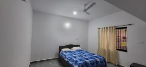 a bedroom with a bed and a ceiling fan at Daji Dhabolkar house in Mandrem