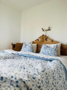 a bed with a blue and white blanket and pillows at Cabin with beautiful view in Kolmården