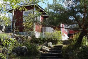 a red brick house with stairs in front of it at Cabin with beautiful view in Kolmården