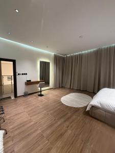 a bedroom with a bed and a desk in it at شاليه اند هوم in Hail