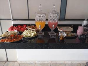 two glasses of drinks on a table with food at Hotel Olympia in Cláudio
