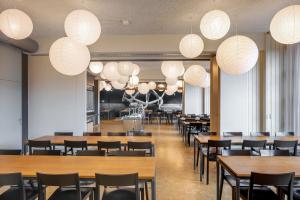 a dining room with tables and chairs and lights at Luzern Youth Hostel in Lucerne