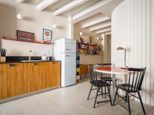 a kitchen with a table and a white refrigerator at Majordoms Retrocentric in Banyoles
