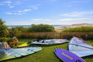 a group of surfboards sitting on the grass near a fence at 14 Penguin Place, Melkbosstrand in Melkbosstrand +20 photos