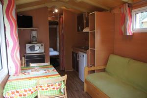 a small room with a couch and a small kitchen at Camping A Torra in Galeria